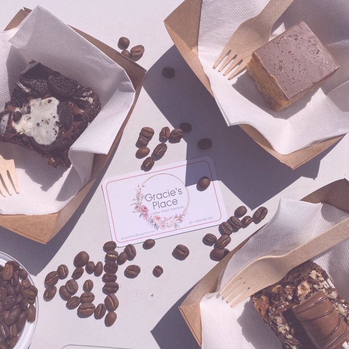 Brownies and slices in kraft trays with coffee beans and a Gracie's Place business card