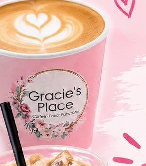 A latte with heart-shaped latte art in a Gracie's Place cup